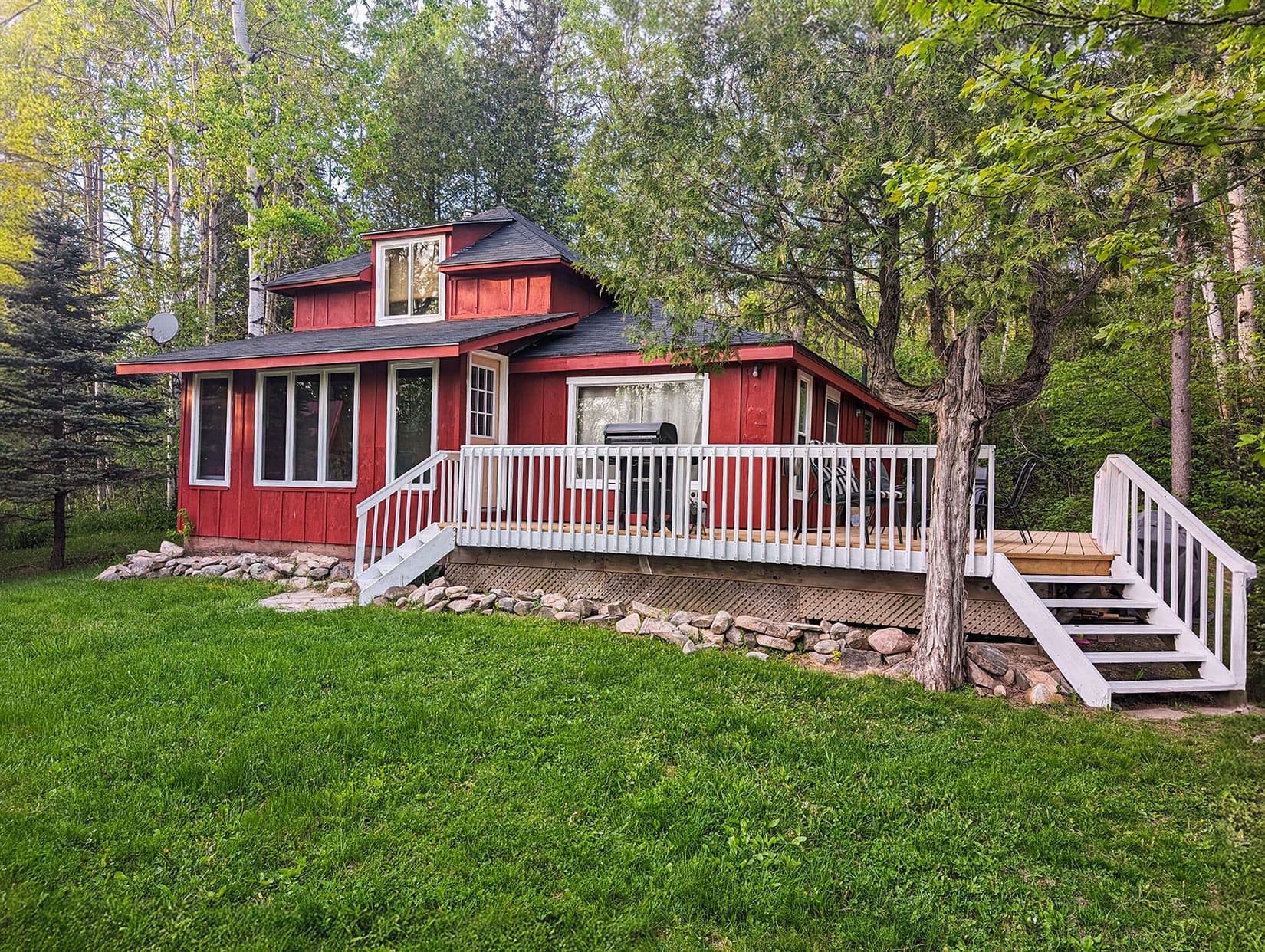 Expansive backyard with plenty of green space, bordered by trees. Ideal for various outdoor activities, from games to relaxation.